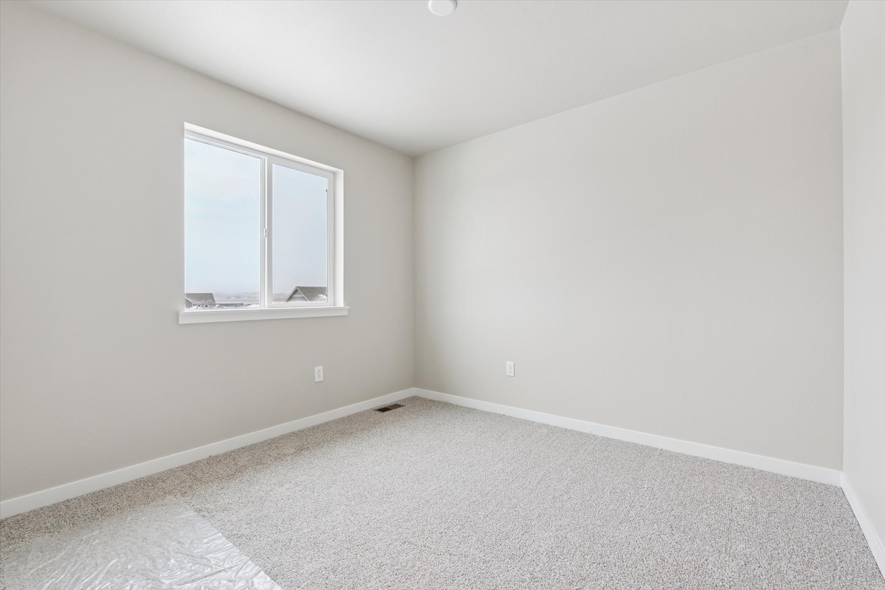 A room with a window and a carpet.