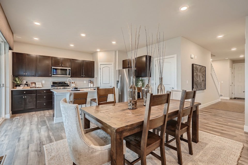 A dining room table with a chandelier from it.