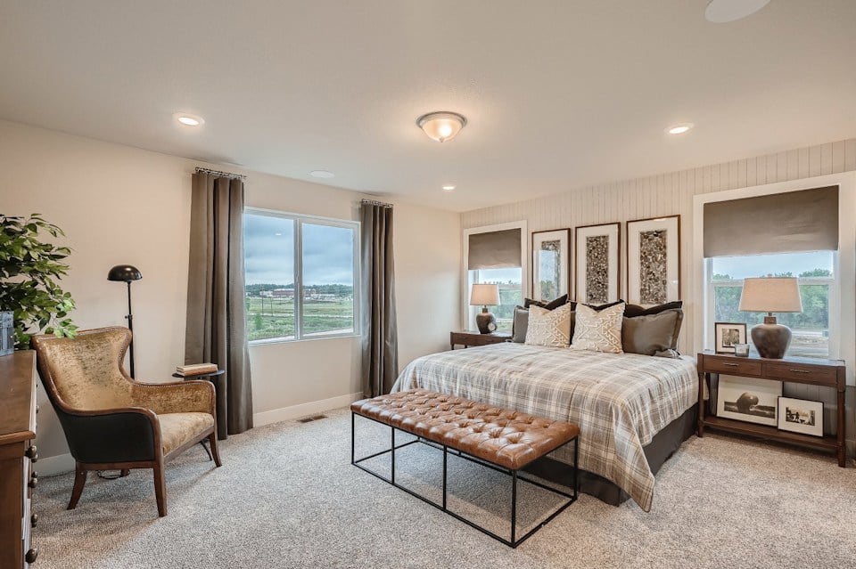 A bedroom with a bed and a chair.