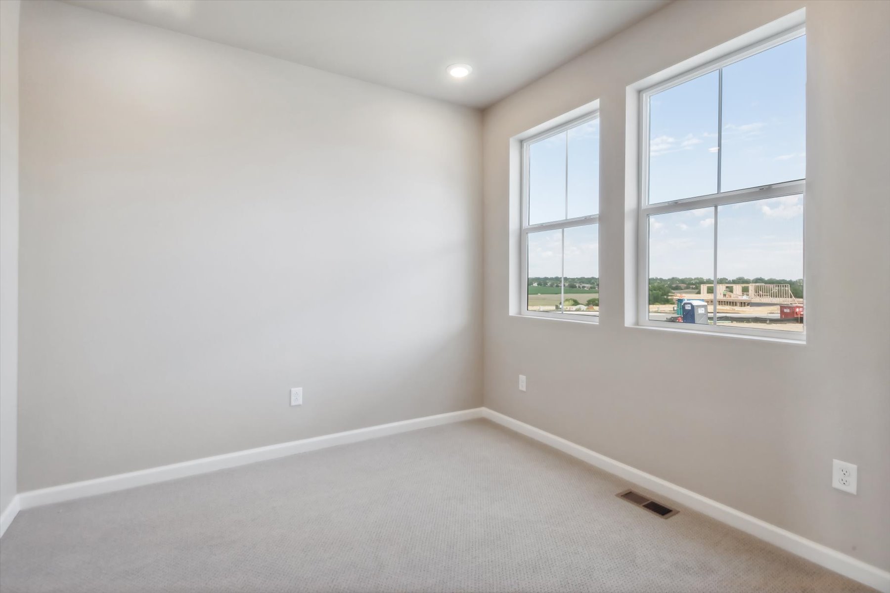 A room with windows and a carpet.