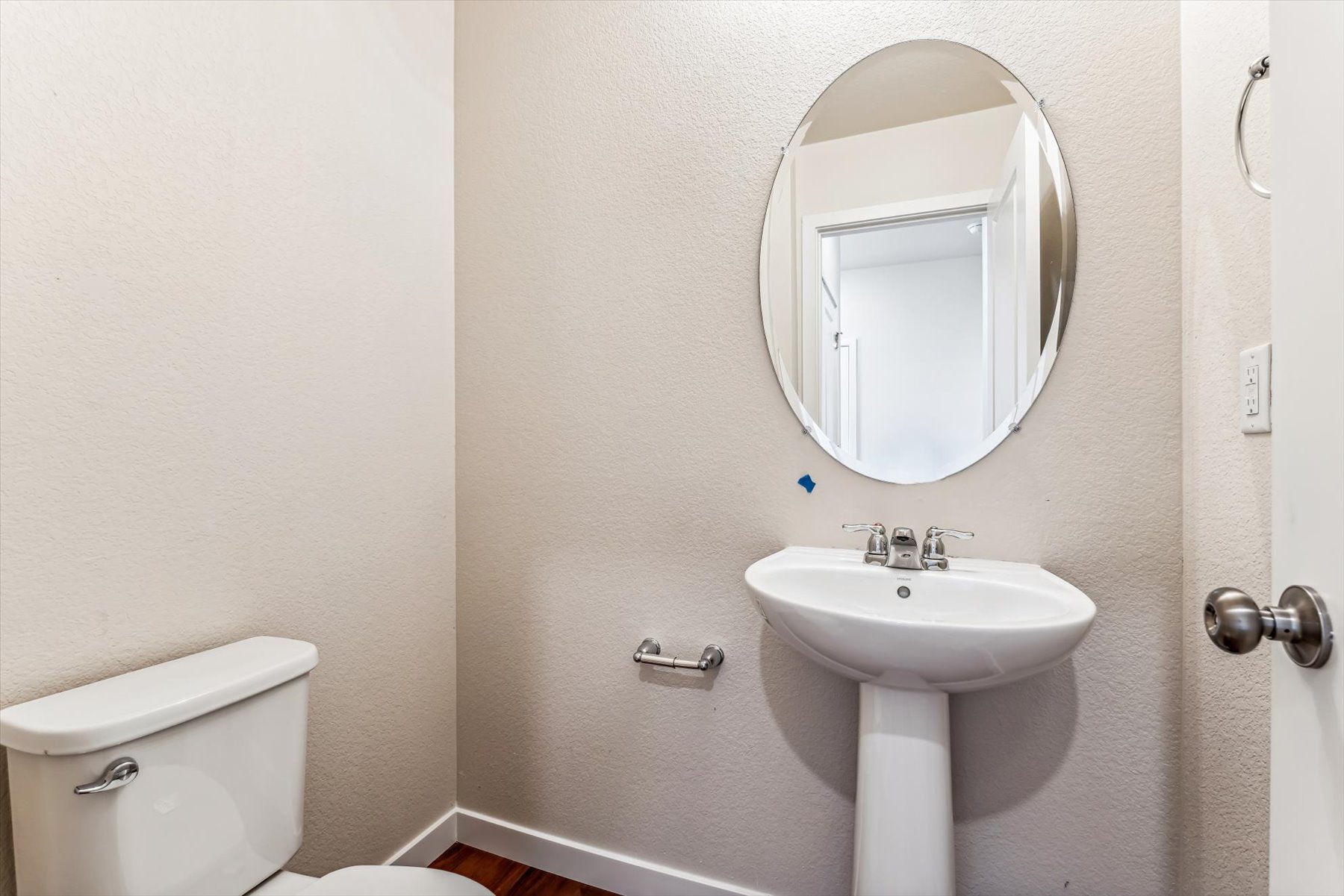 A bathroom with a round mirror.