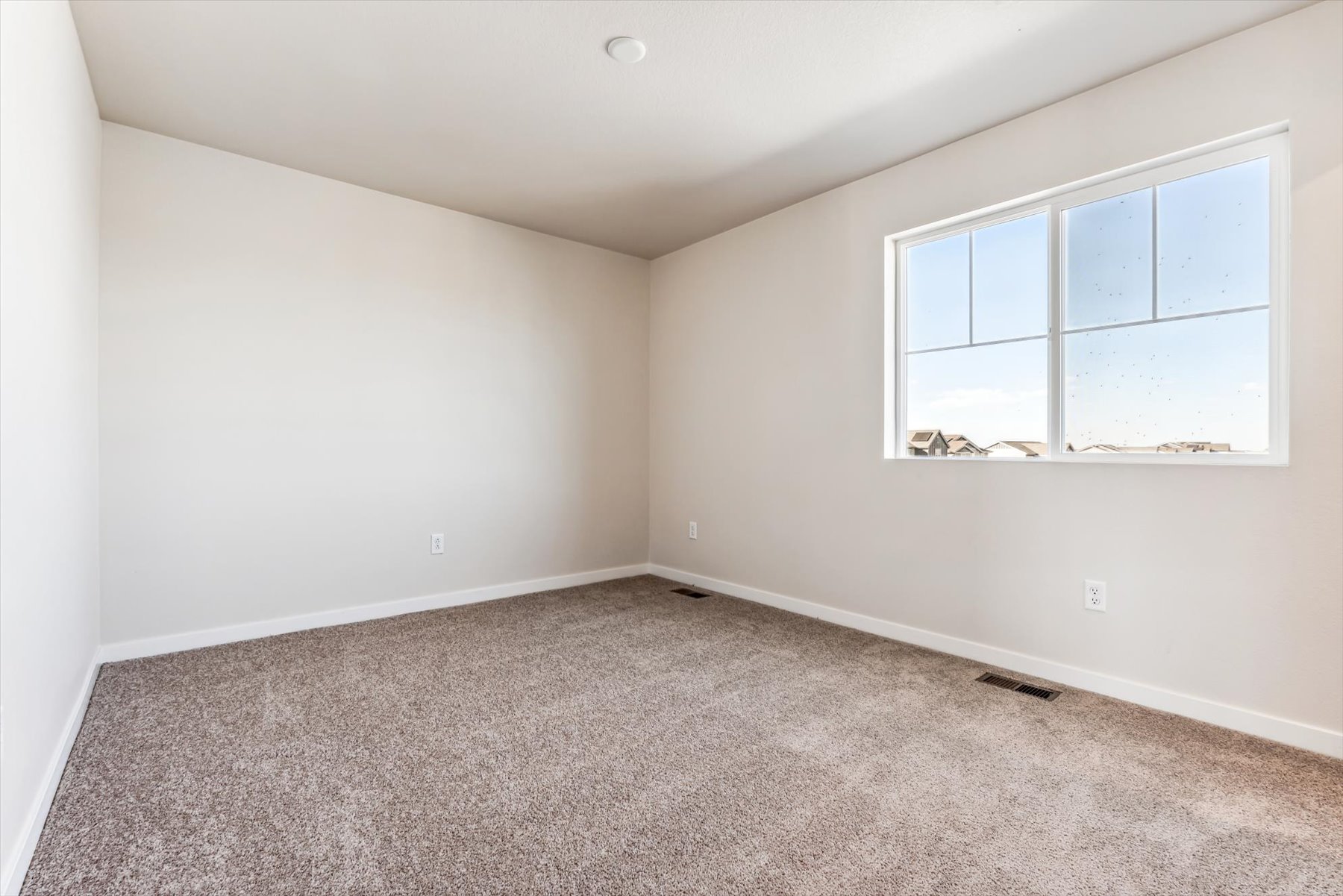 A room with a window and carpet.