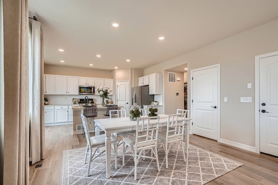 A kitchen with a dining table and chairs.