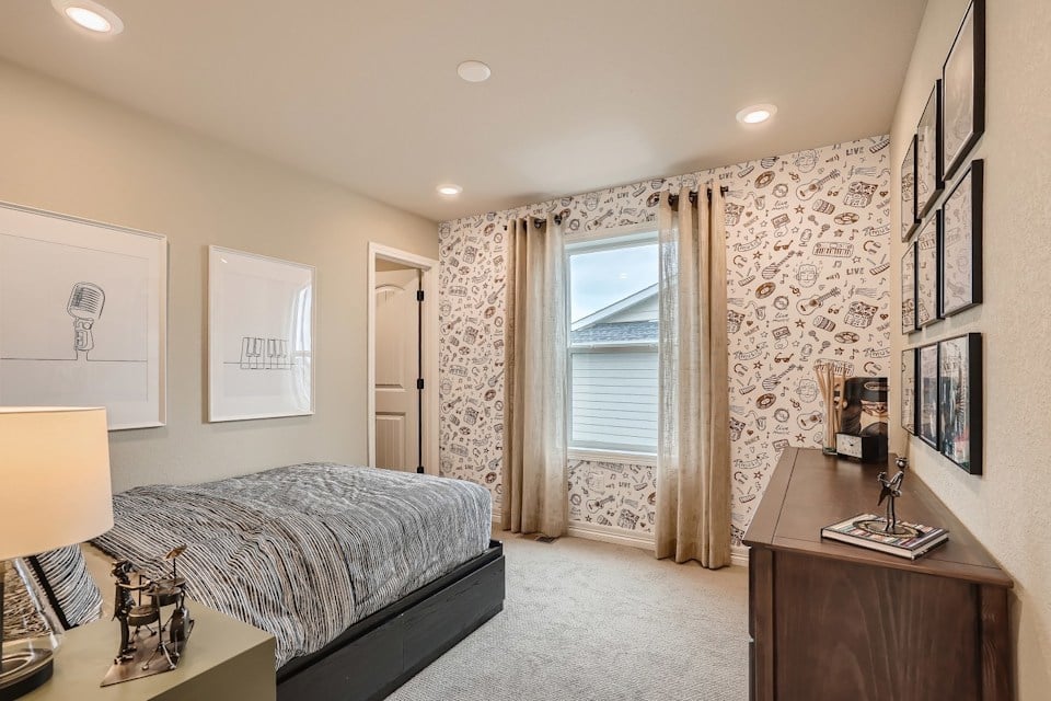 A bedroom with a bed and a desk.