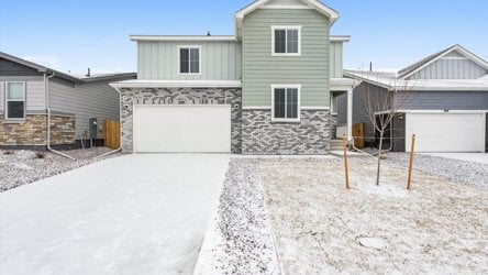 A house with a garage and a snow covered yard.