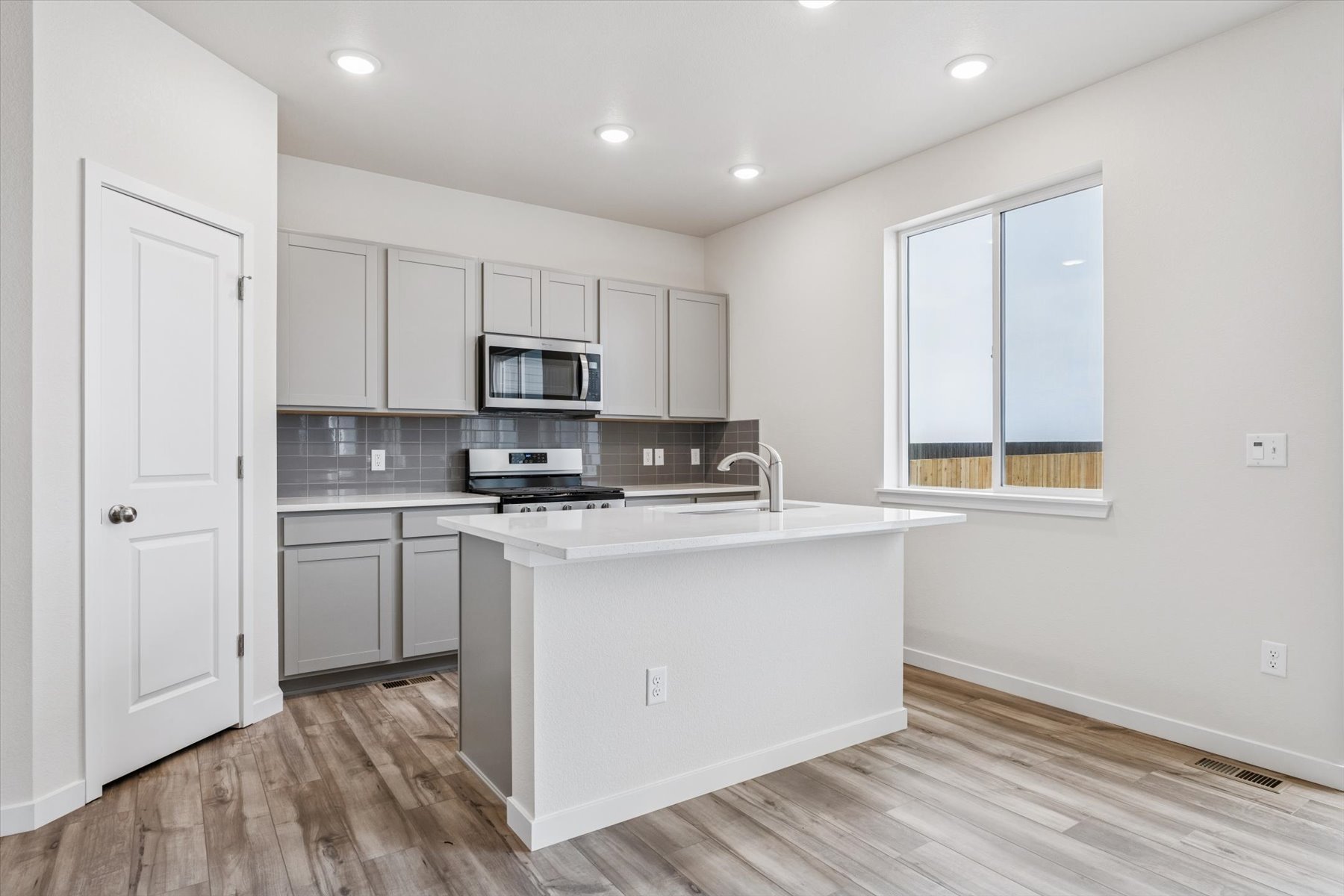 A kitchen with white cabinets.