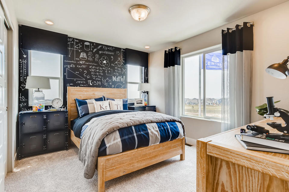 A bedroom with a bed and desk.