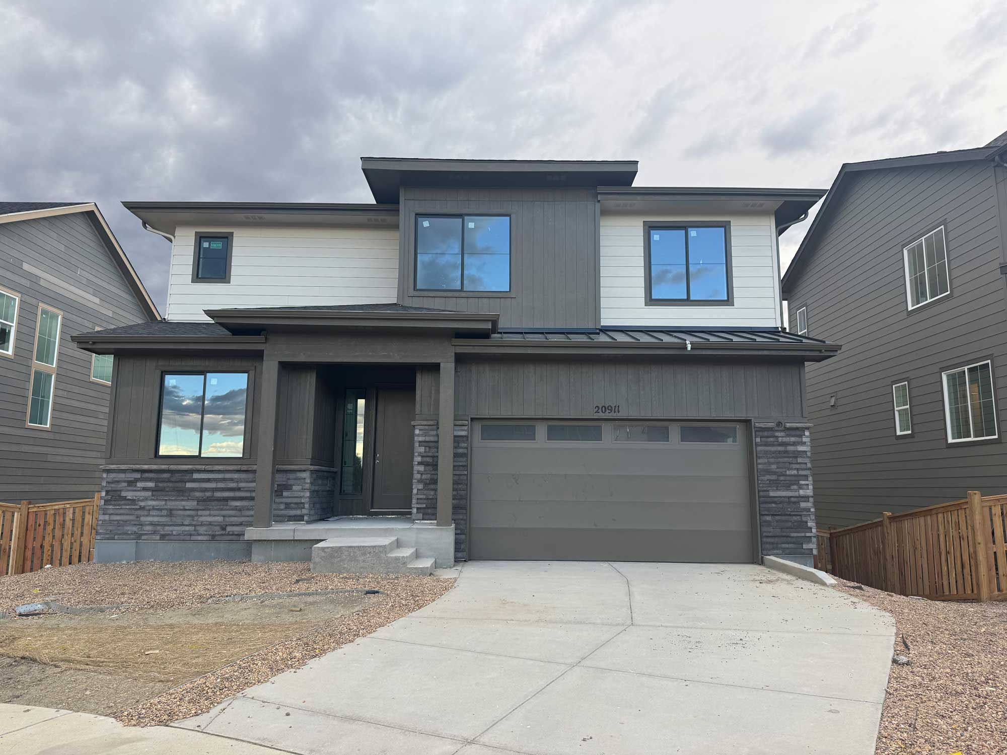 A grey house with a garage.