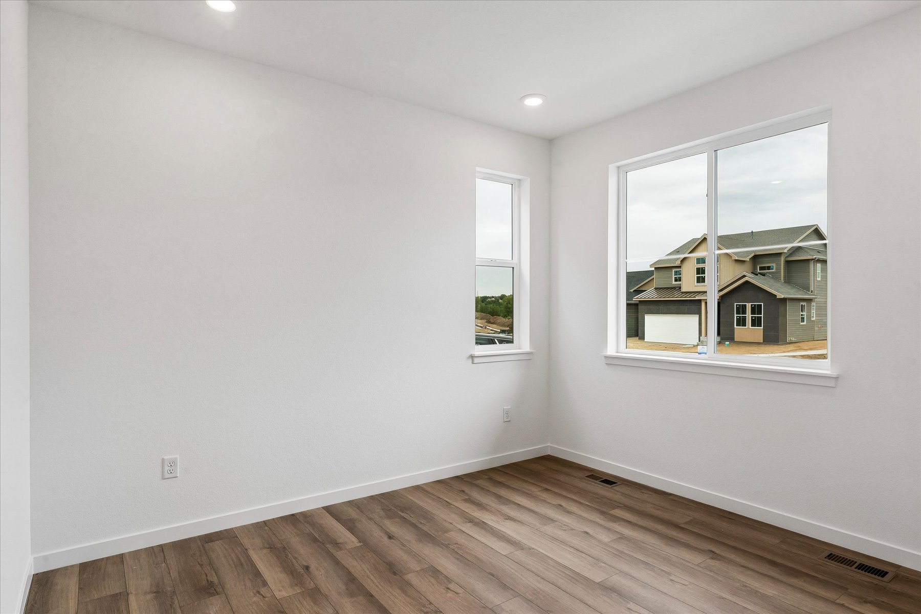 A room with a wood floor and a window with a wood floor.