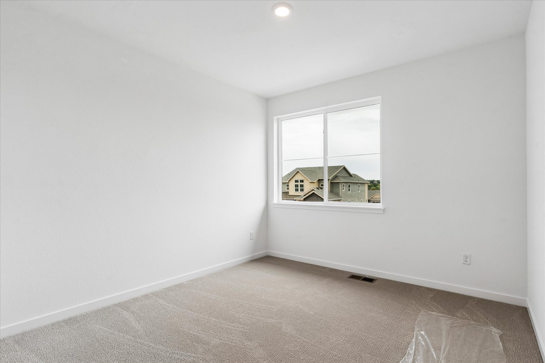 A room with a window and a carpet.