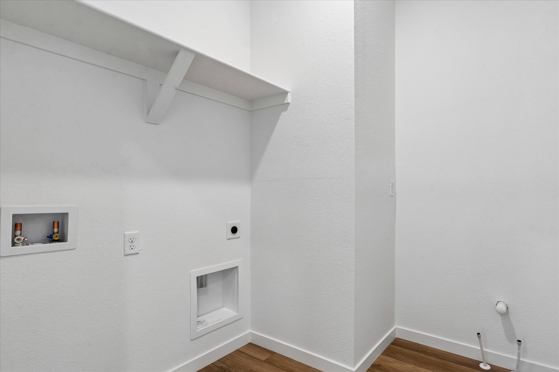 A white room with a wood floor and a white ceiling.