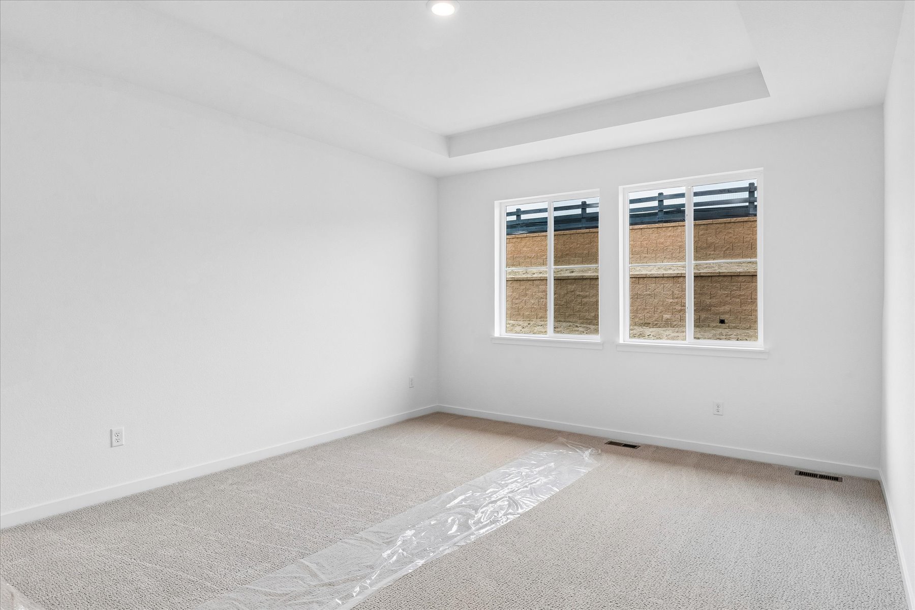 A room with a window and a rug.