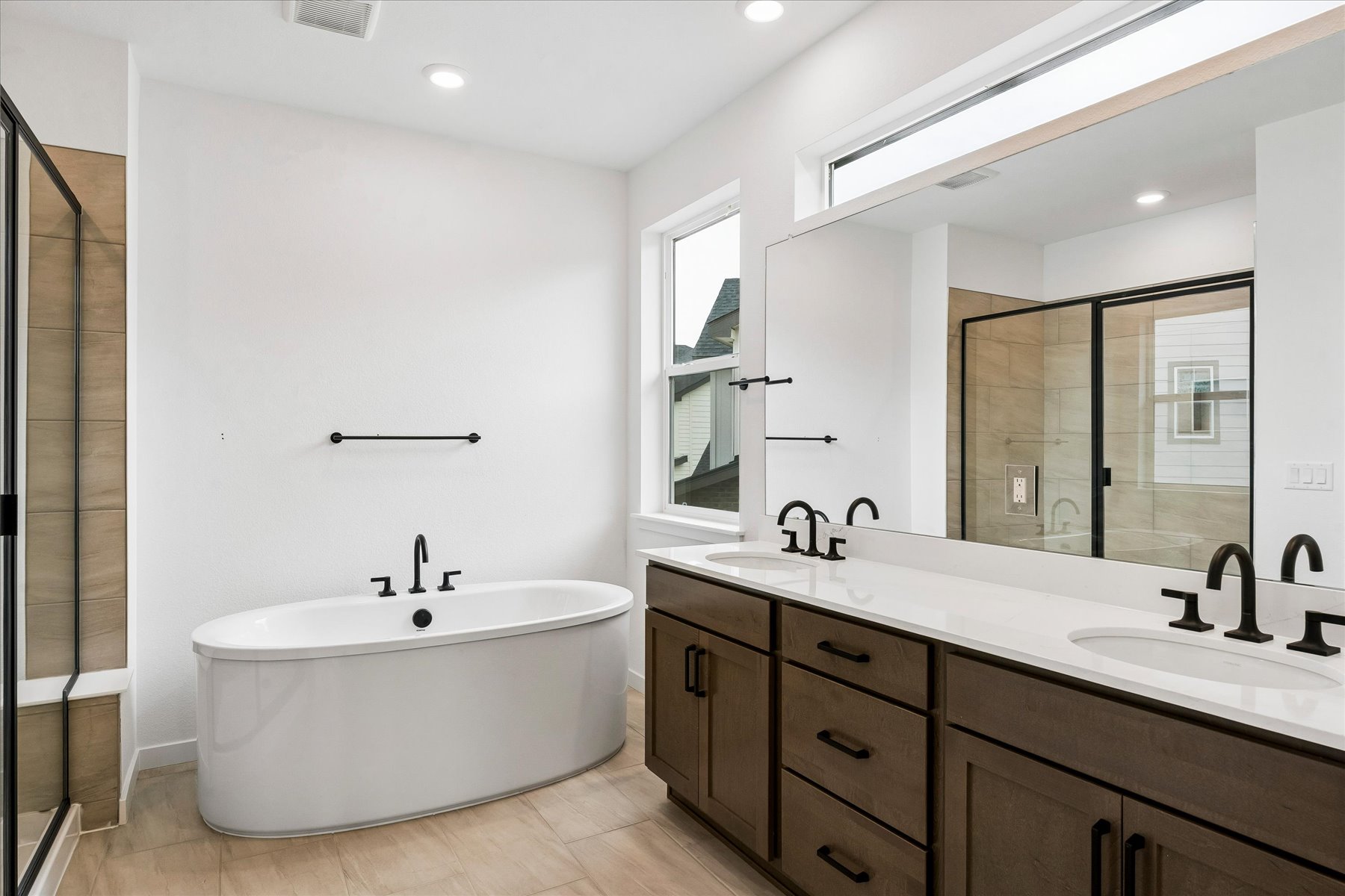 A bathroom with a tub sink and mirror.