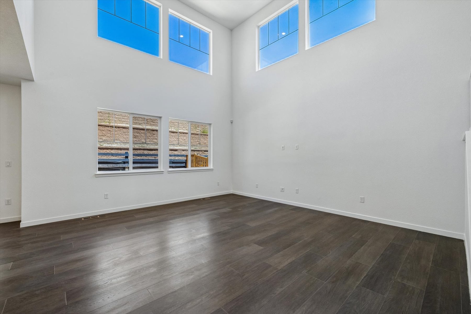 A room with a wood floor and blue windows.