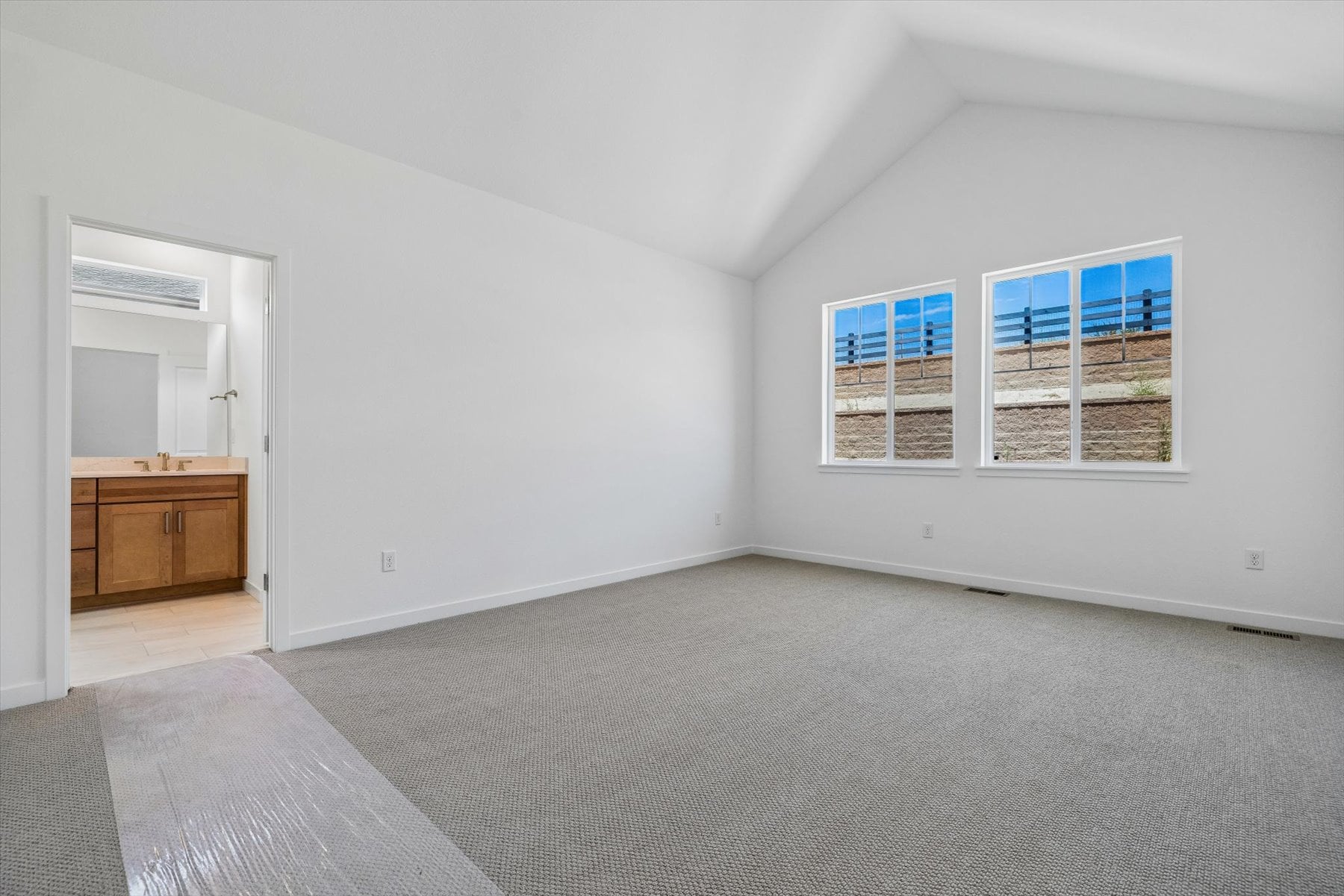 A room with a carpet and a desk.