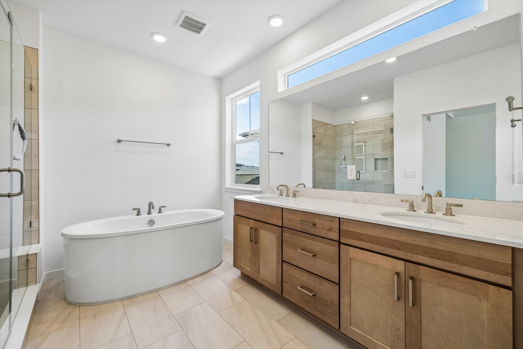 A bathroom with a tub sink and mirror.