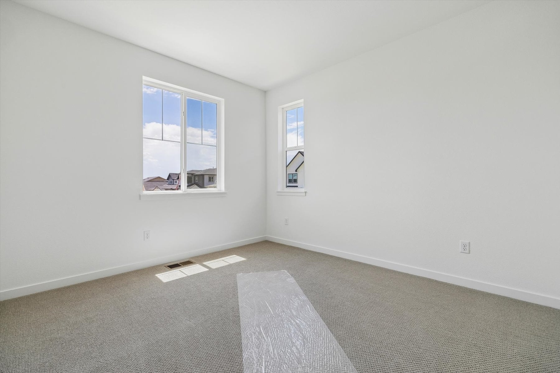A room with a rug and windows.