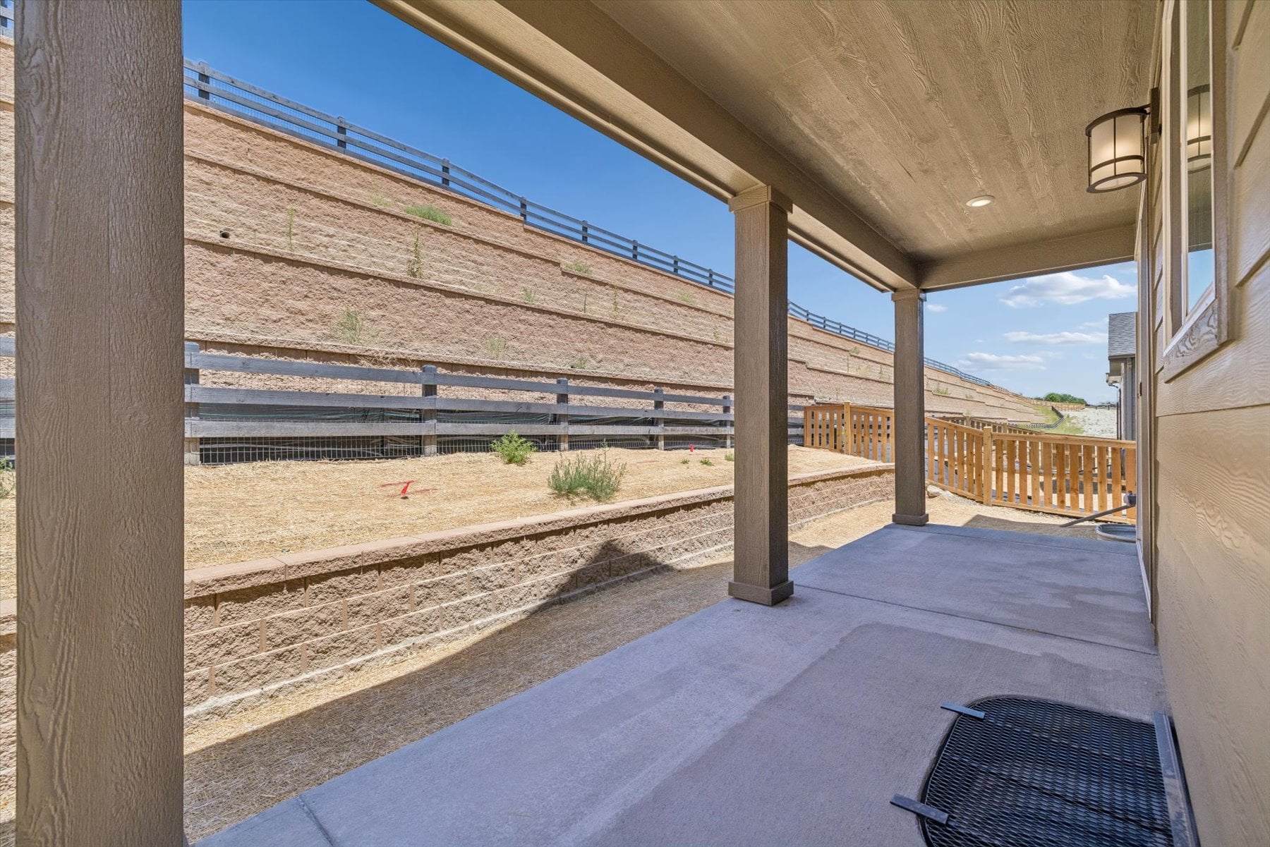 A deck with a wood railing and a wood railing with a body of water in the background.