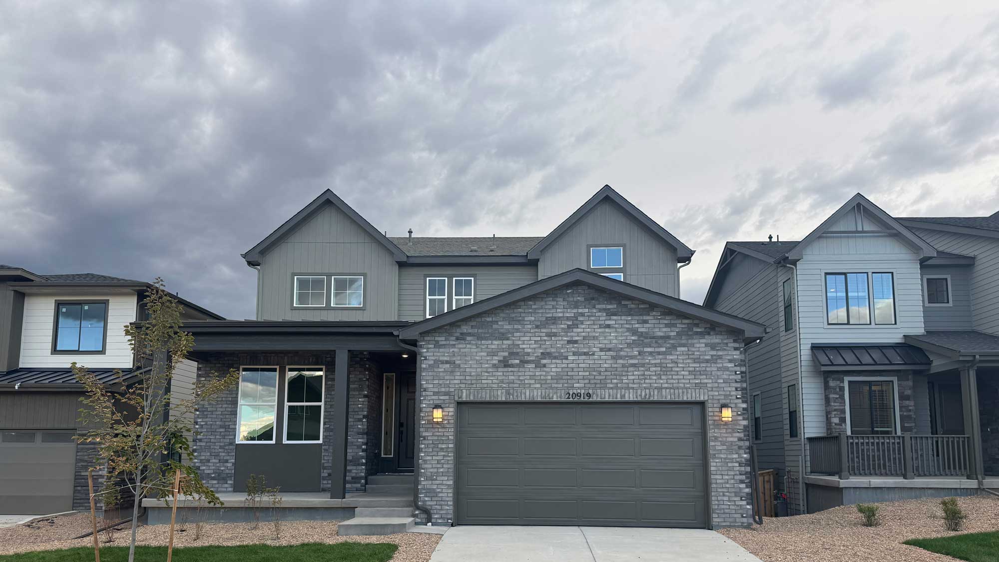 A grey house with a garage.