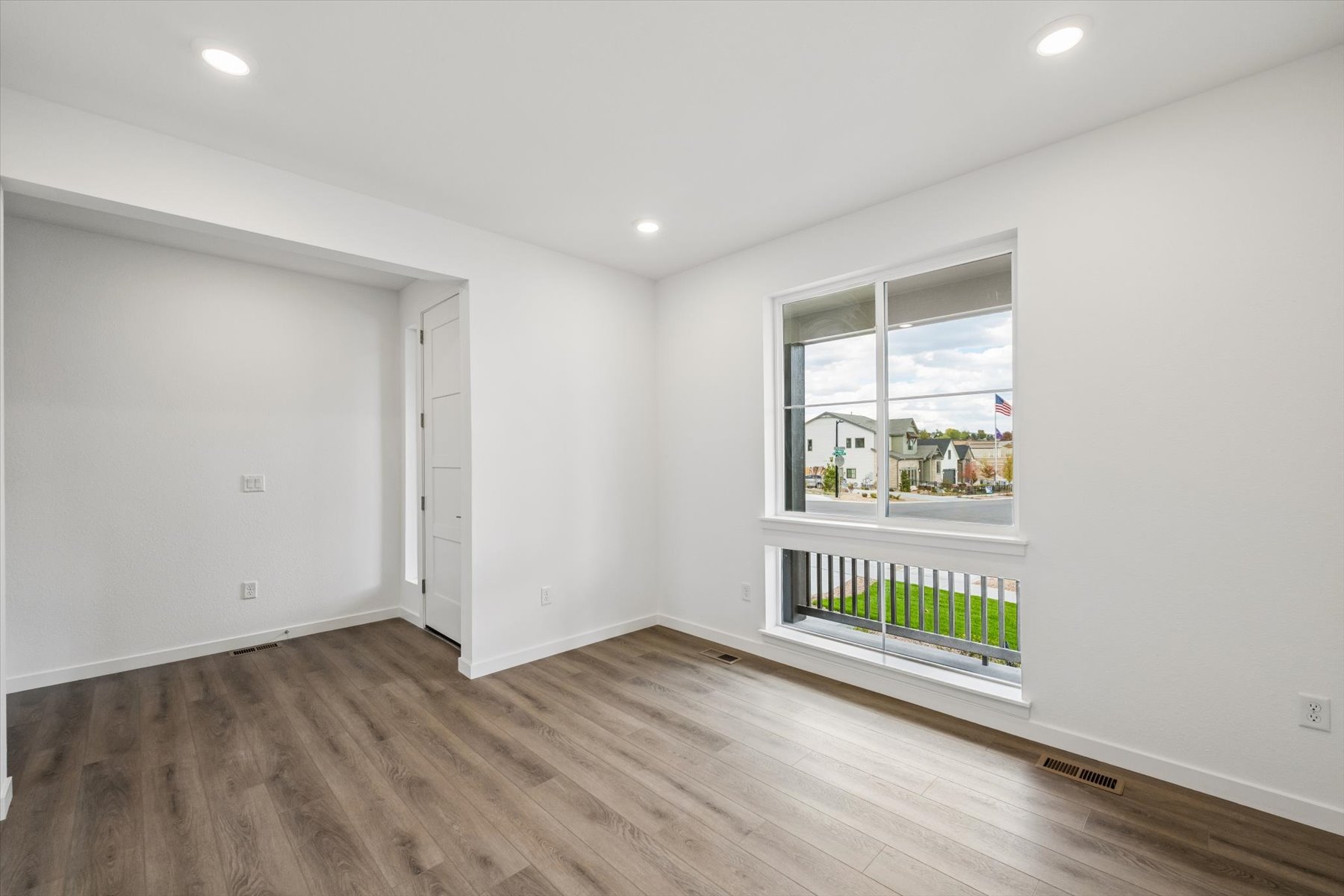 A room with a wood floor and a window.