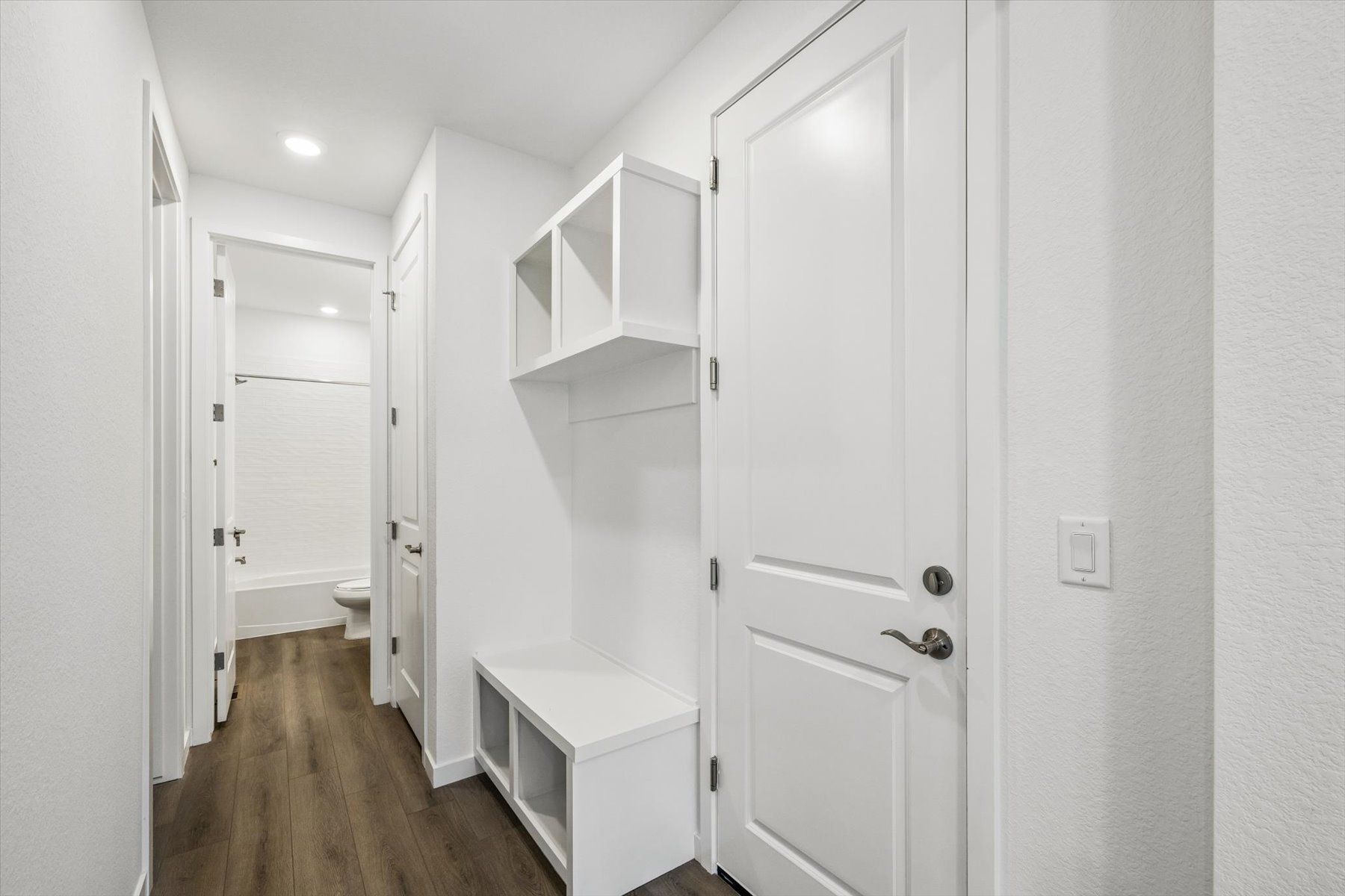 A white bathroom with white doors.