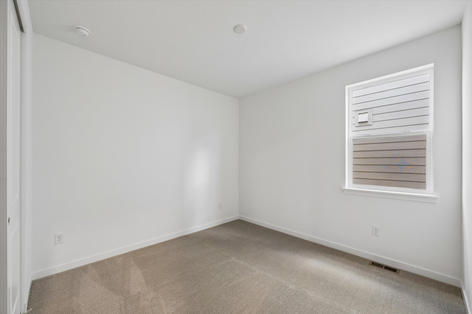 A room with a carpet and a window.