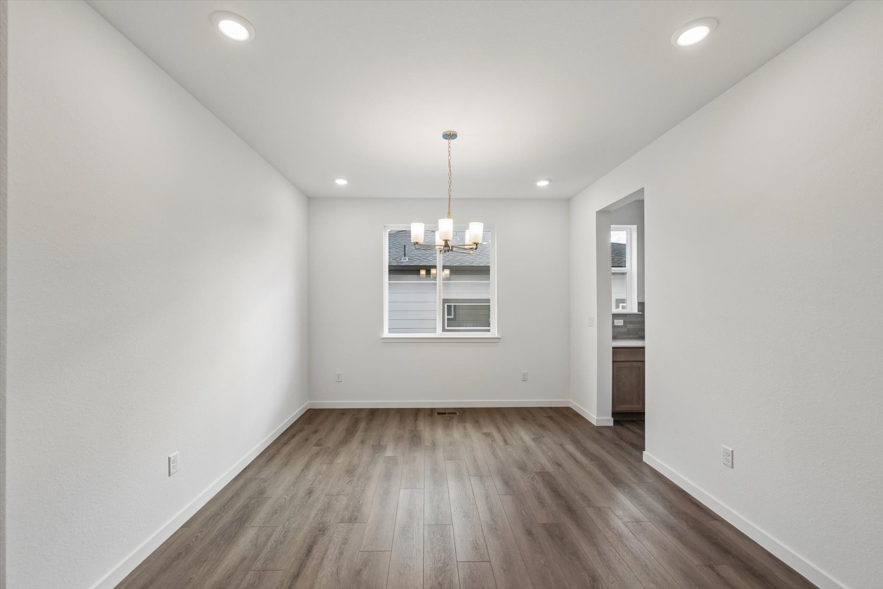 A room with a wood floor and a wood floor with a light on the wall.
