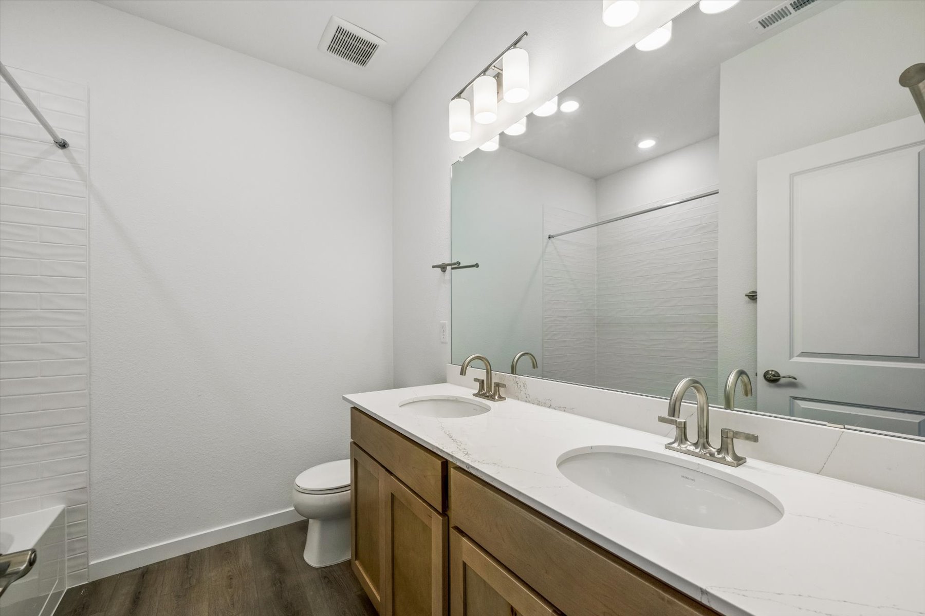 A bathroom with a large mirror.
