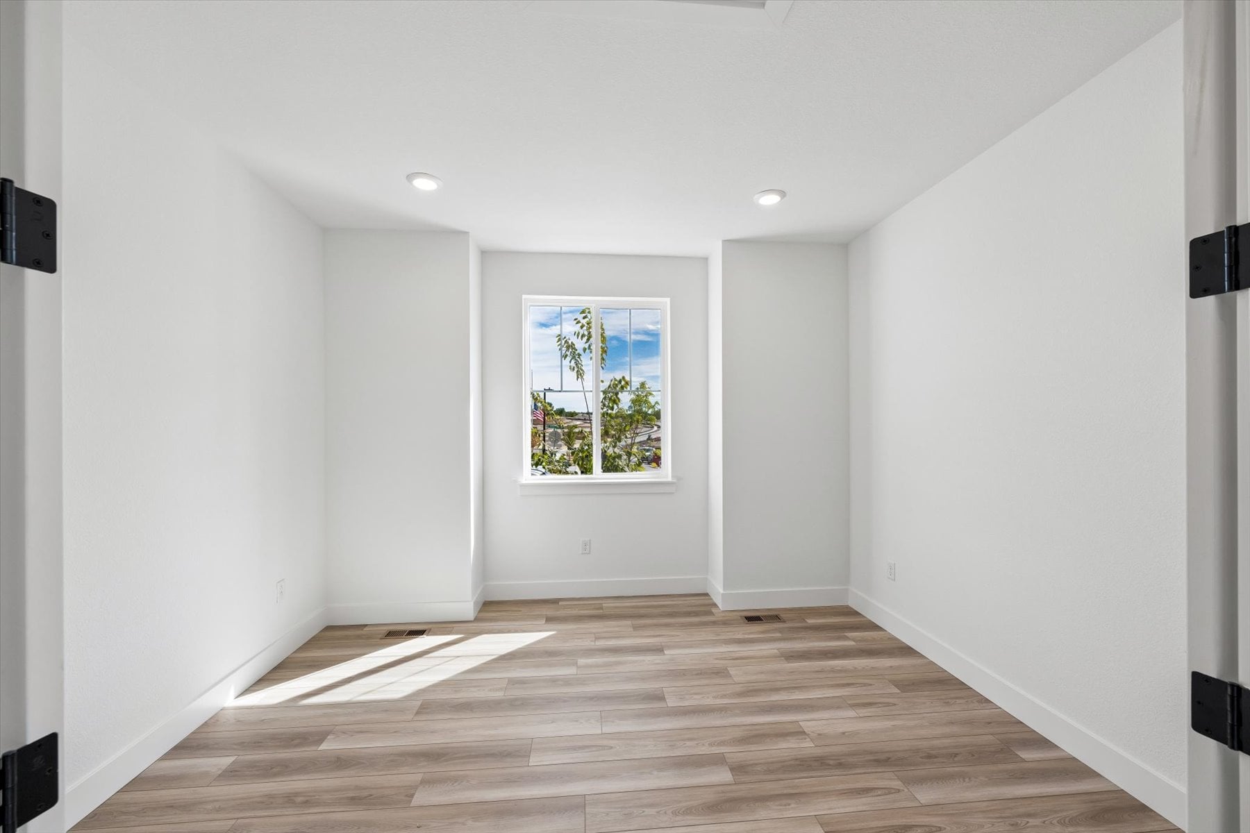 A room with a wood floor and a window.