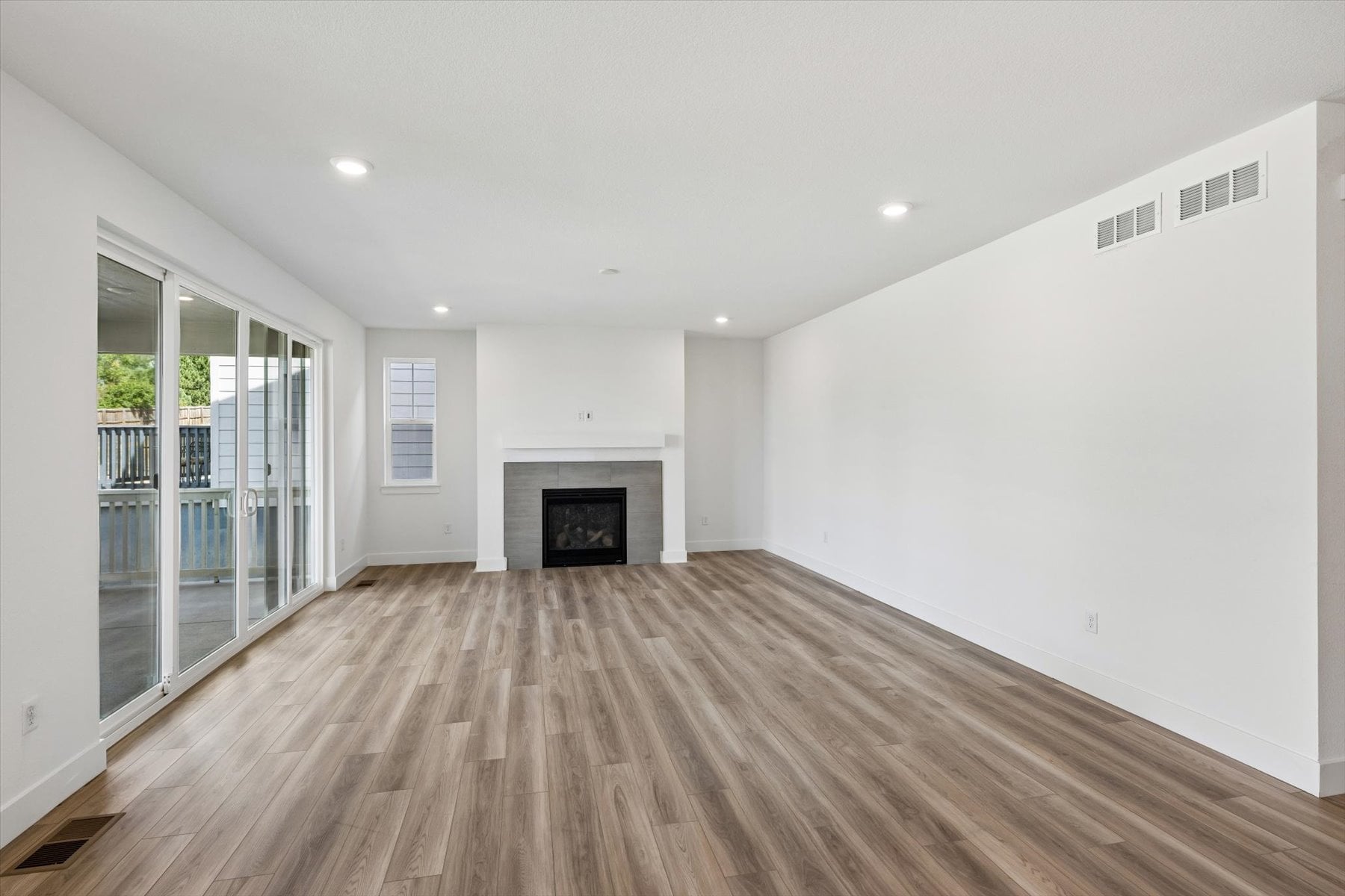 A room with a fireplace and a wood floor.