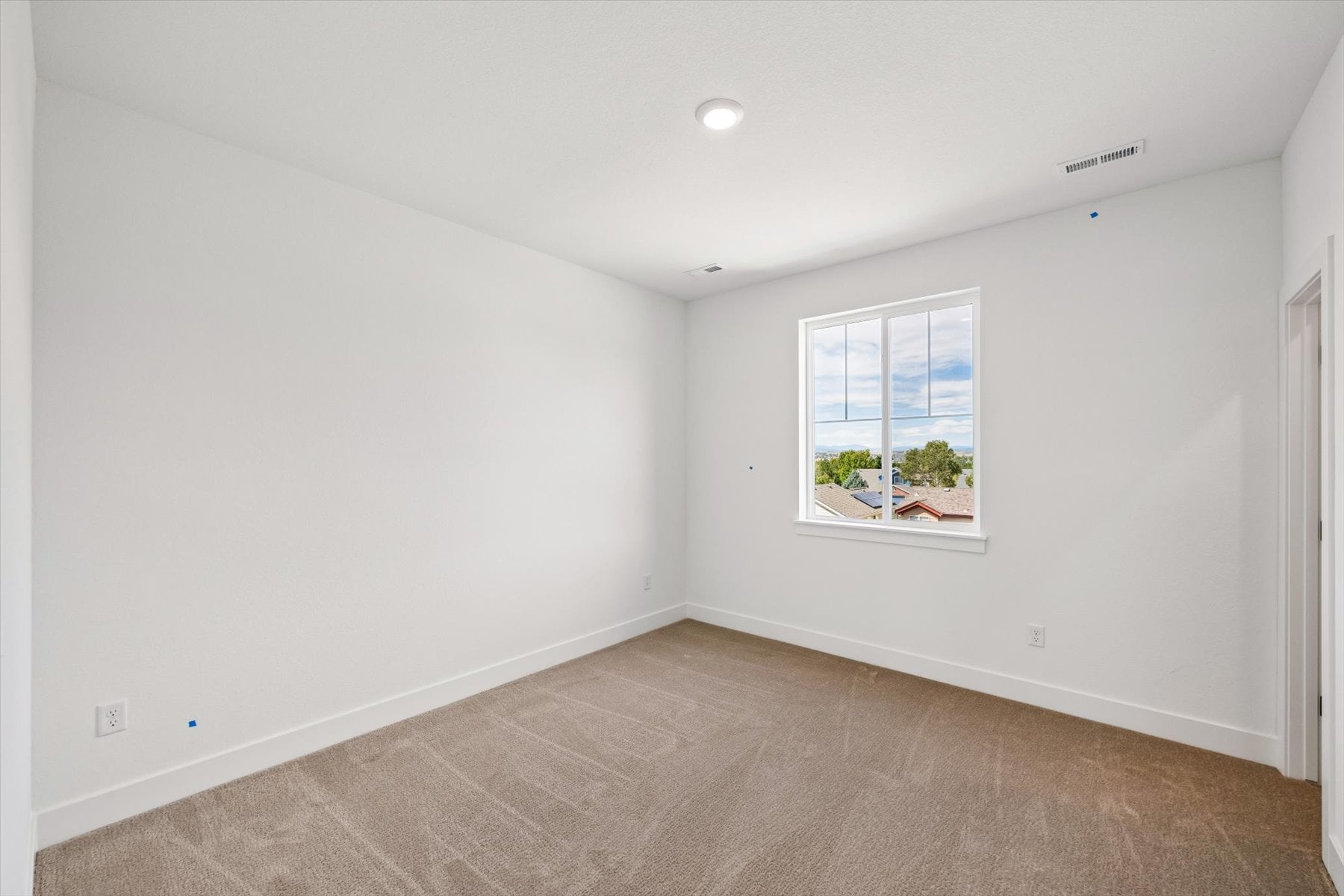 A room with a window and a carpet.