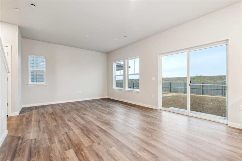 A room with a wood floor and windows.