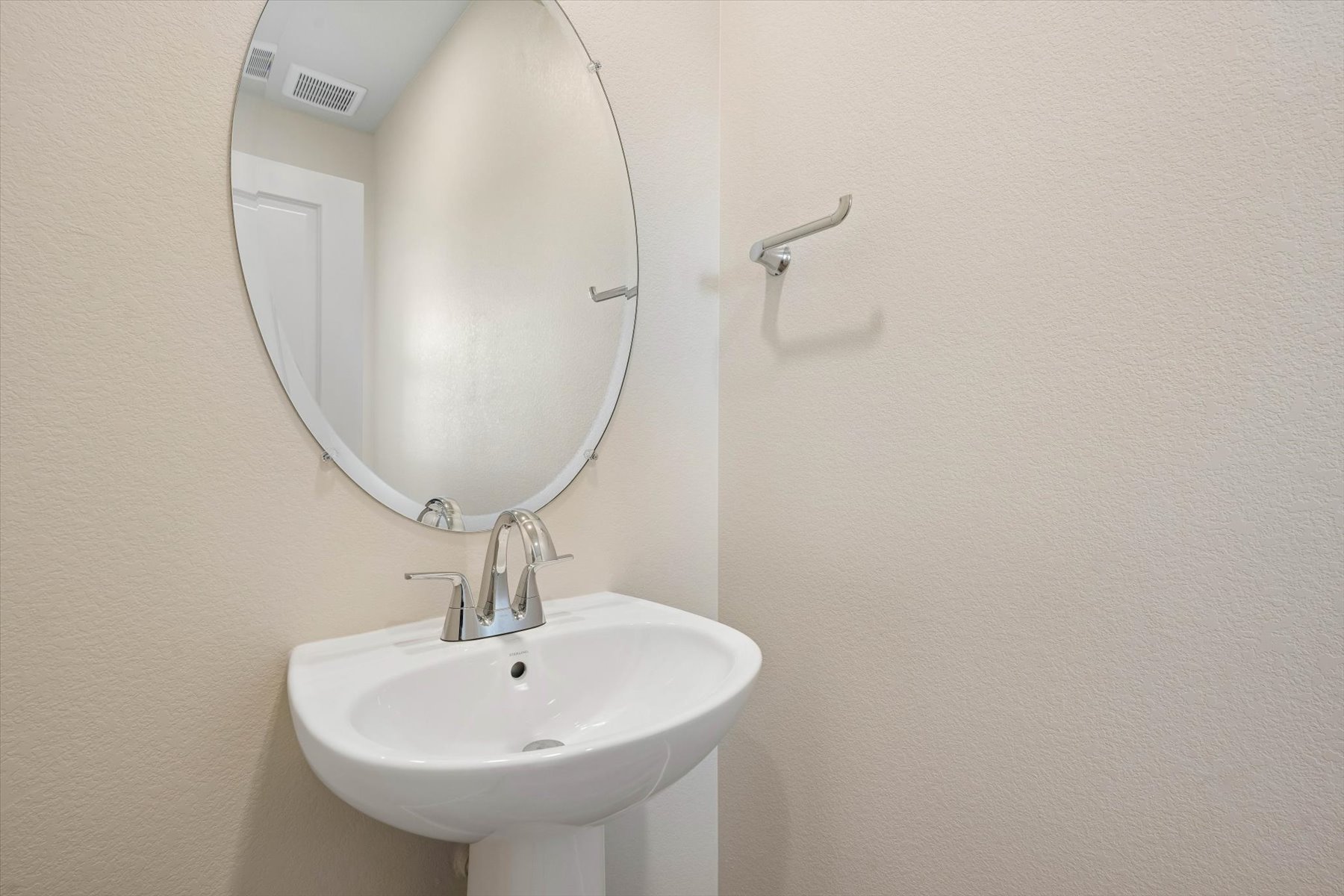 A bathroom with a round mirror.