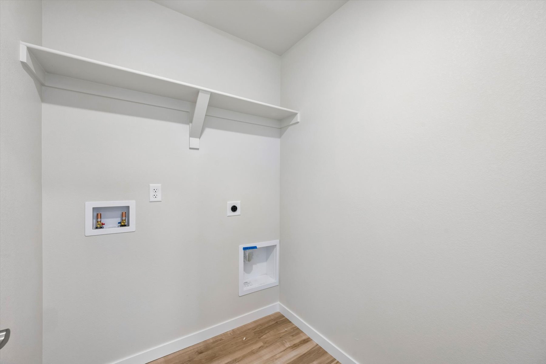 A white room with a wood floor and a wood floor.