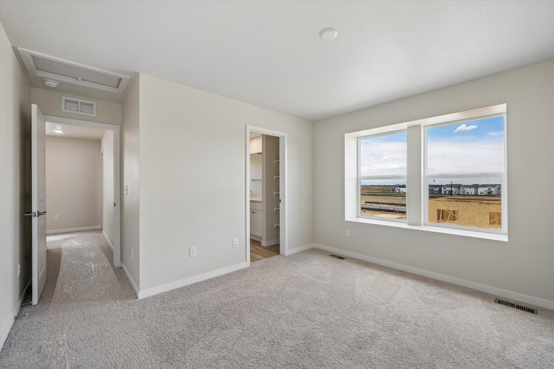 A room with a window and a door with a view of the city.