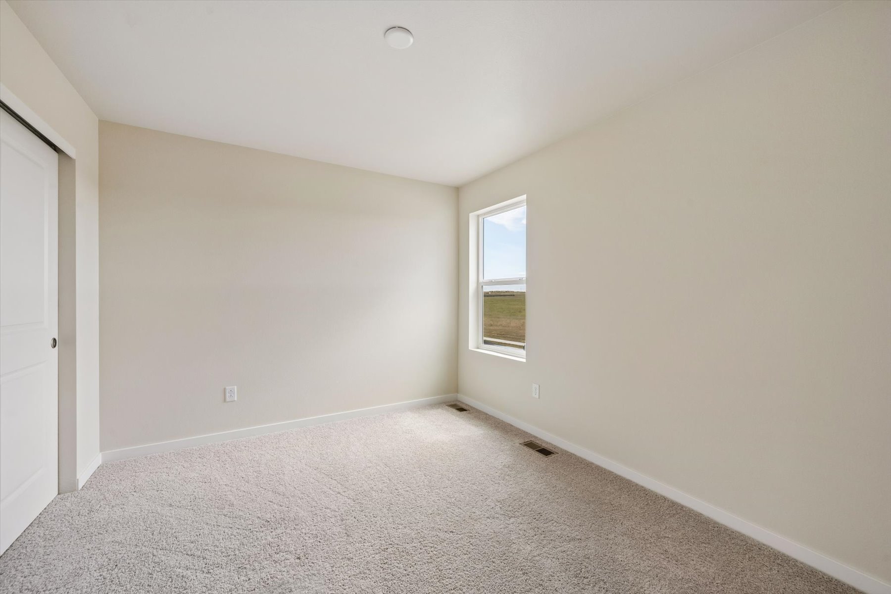 A room with a window and carpet.