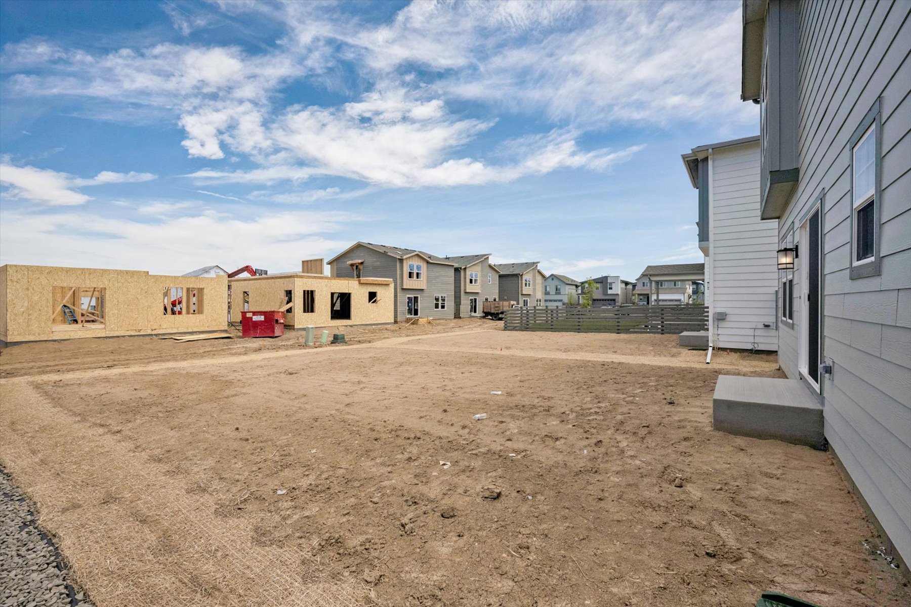 A dirt road between buildings.