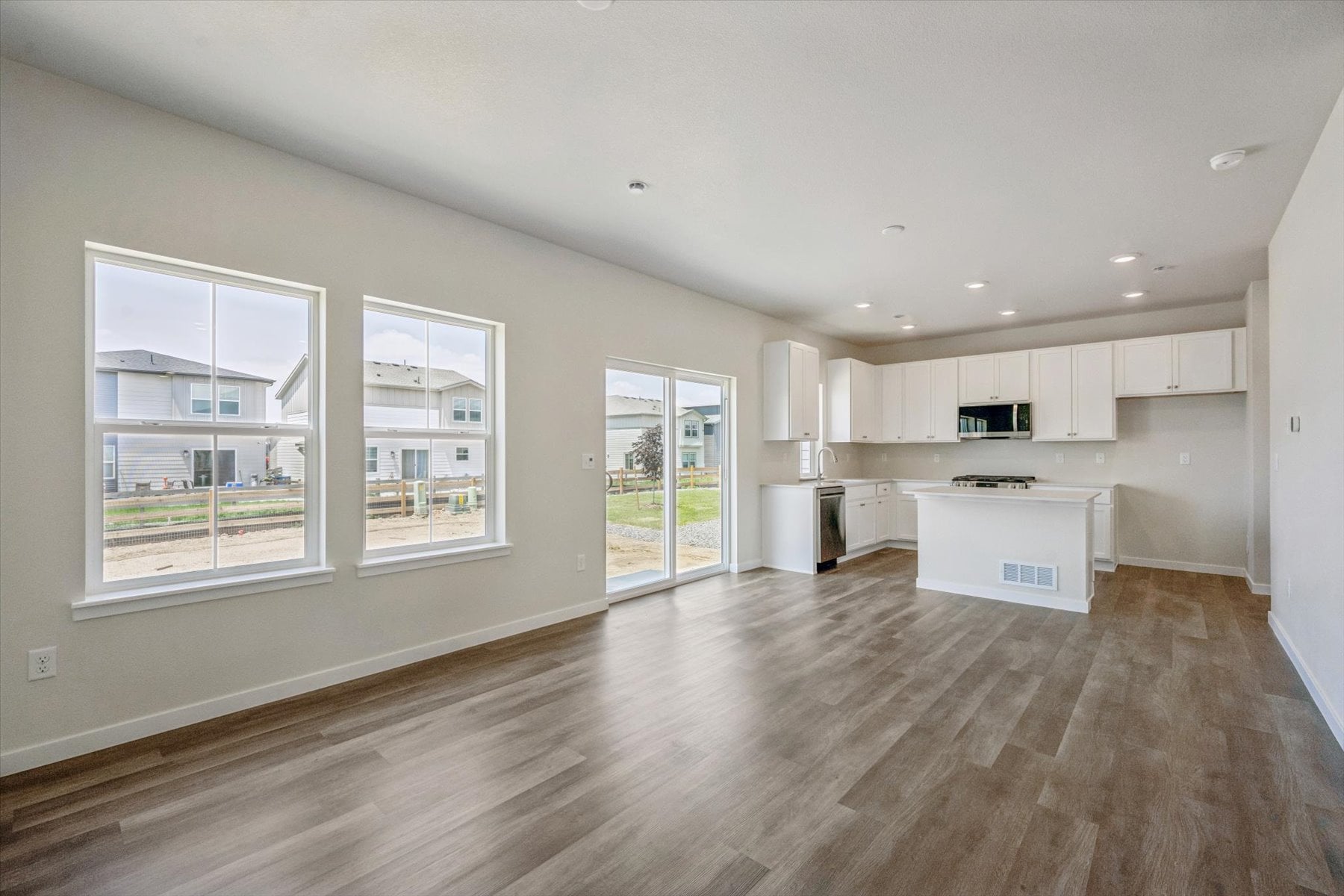 A large empty room with white cabinets.