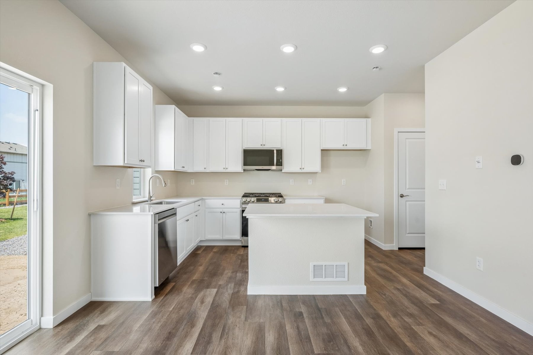 A kitchen with white cabinets.