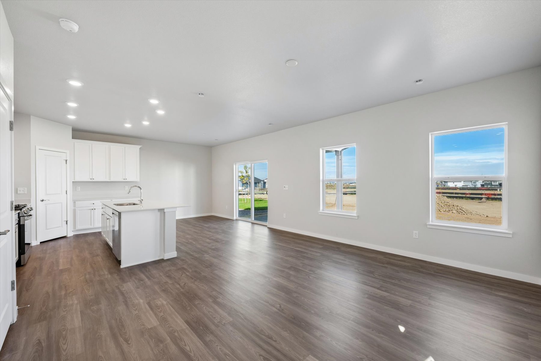 A large empty room with white cabinets.