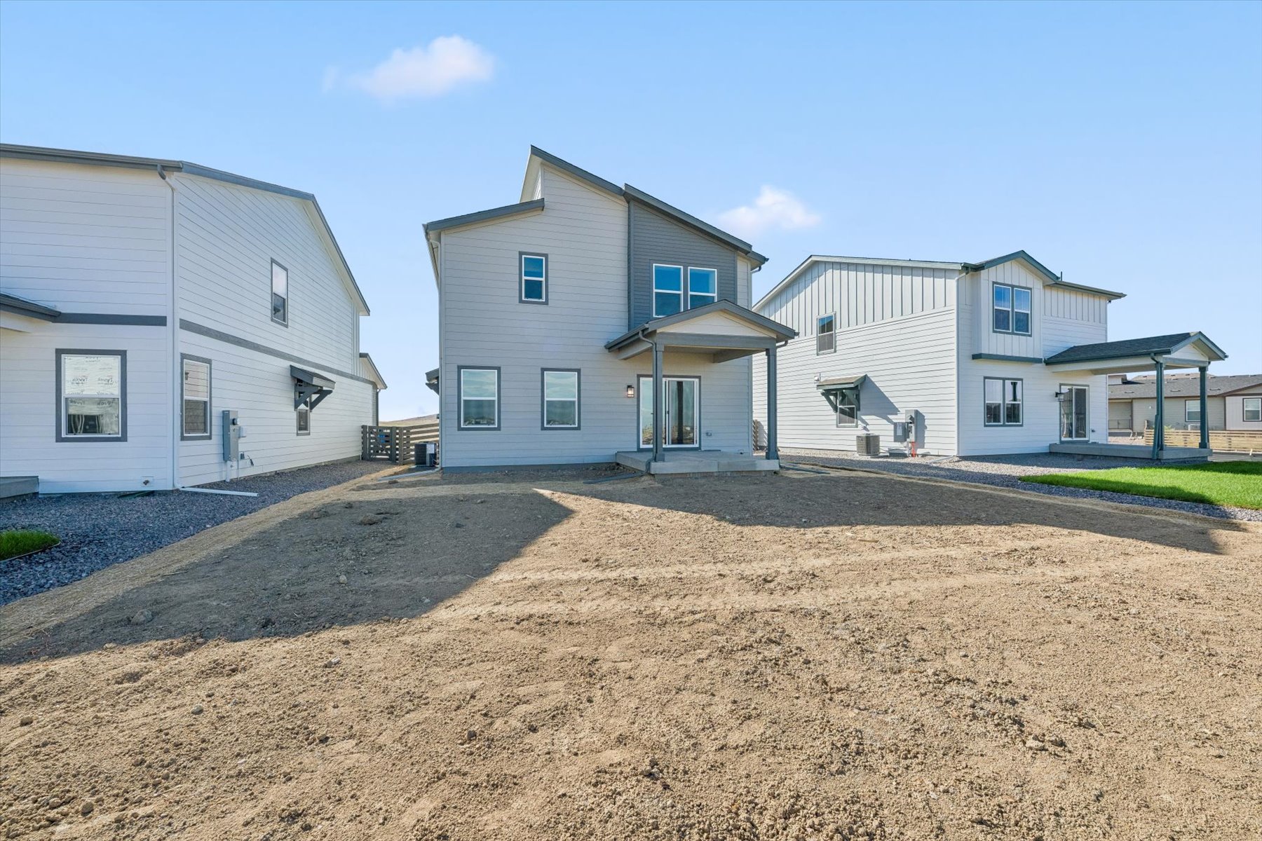A dirt road leading to a row of houses.