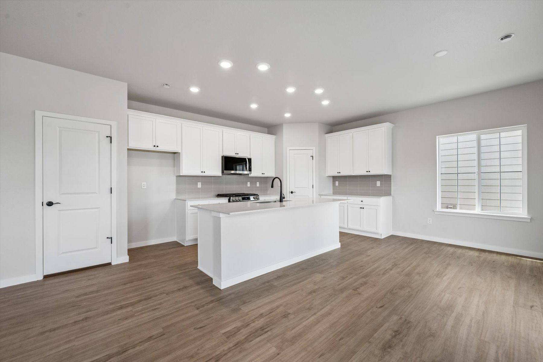 A kitchen with white cabinets.