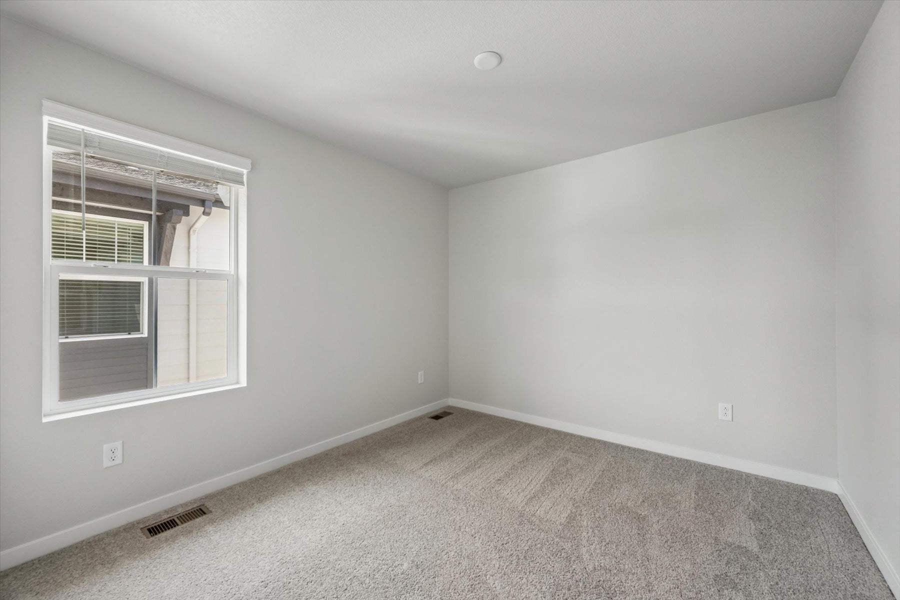 A room with a window and a carpet.