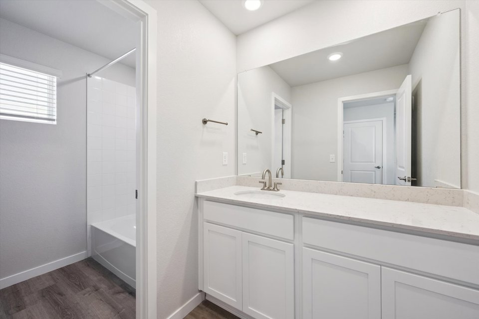 A bathroom with a sink and a shower unit.