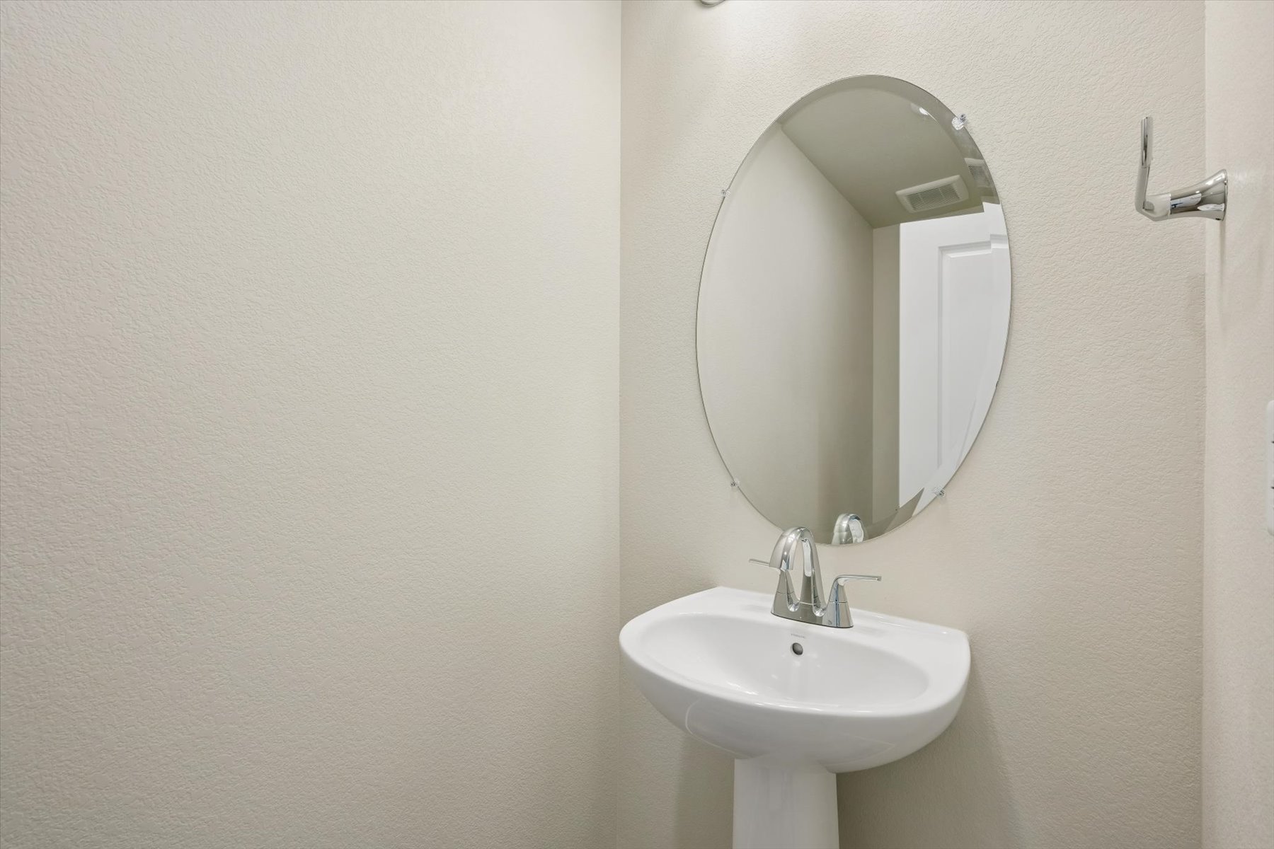 A bathroom with a round mirror.