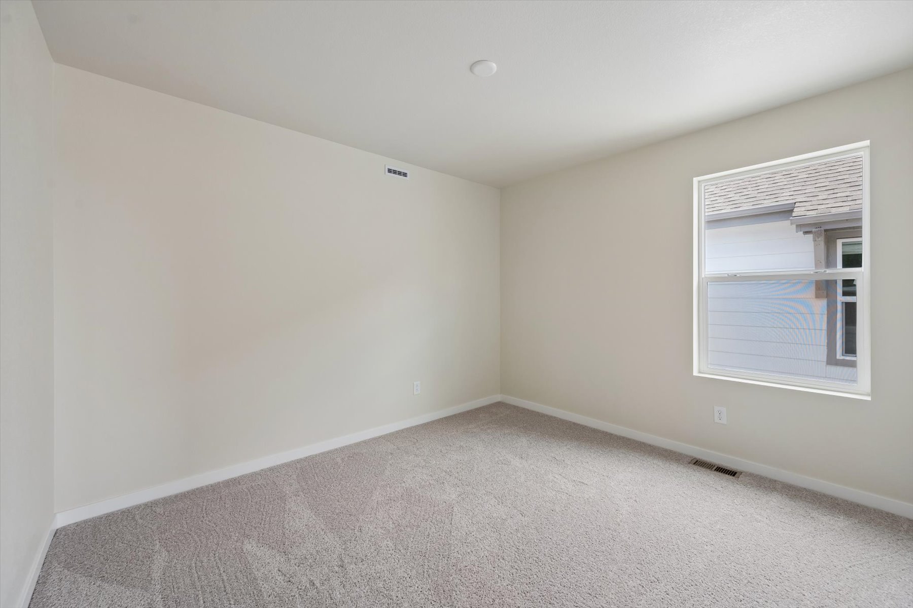 A room with a window and a carpet.