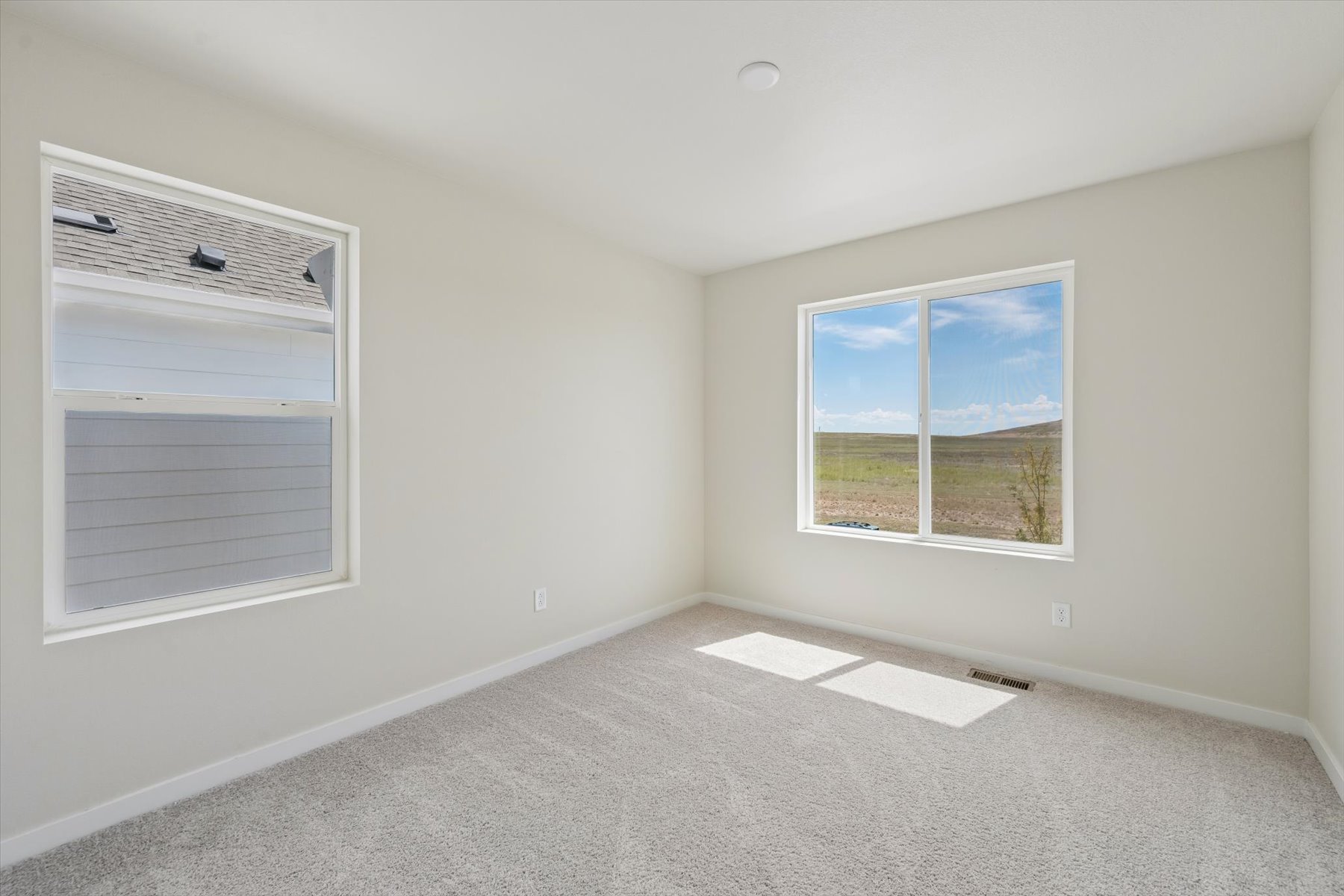 A room with a window and a rug.