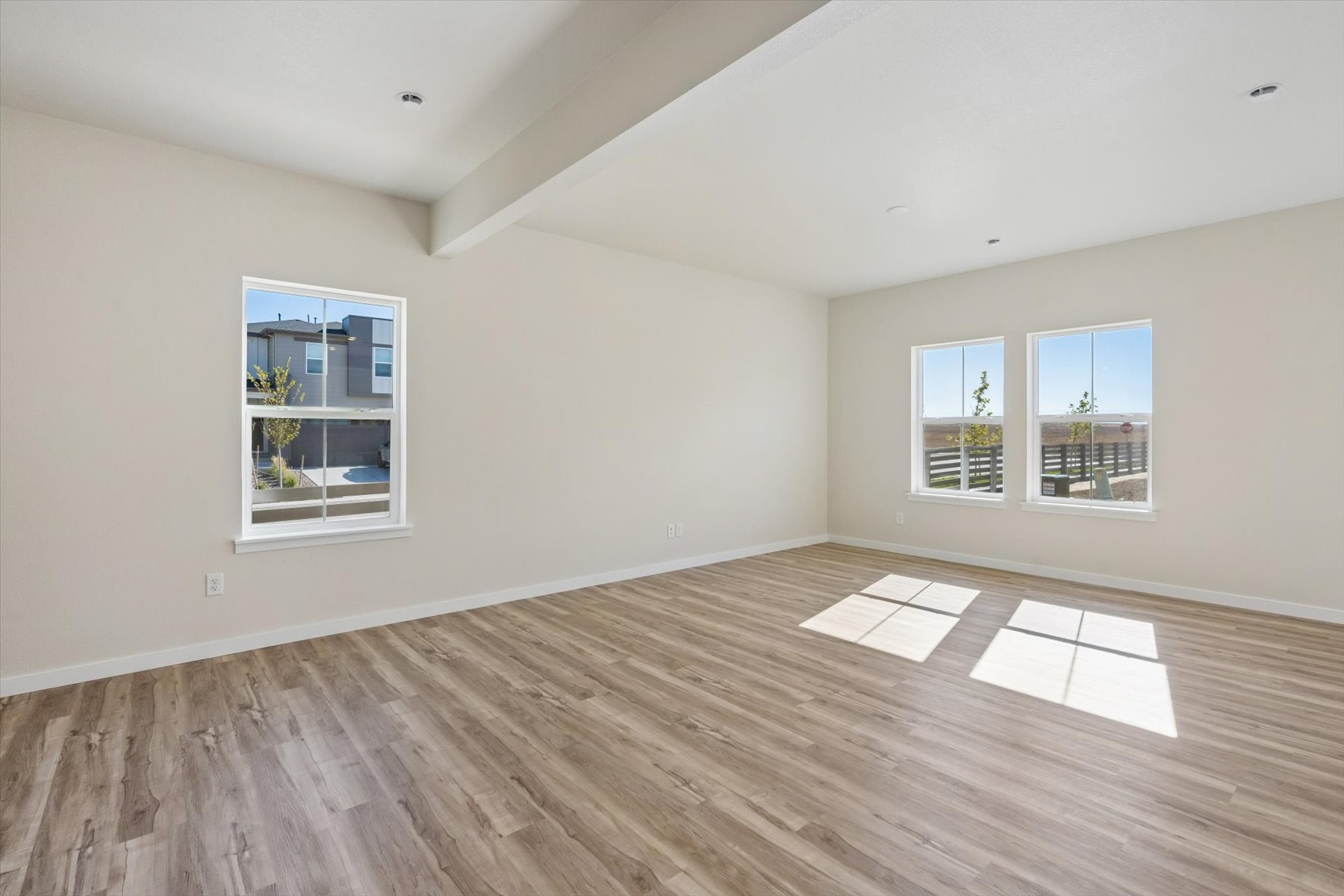 A room with a wood floor and windows.