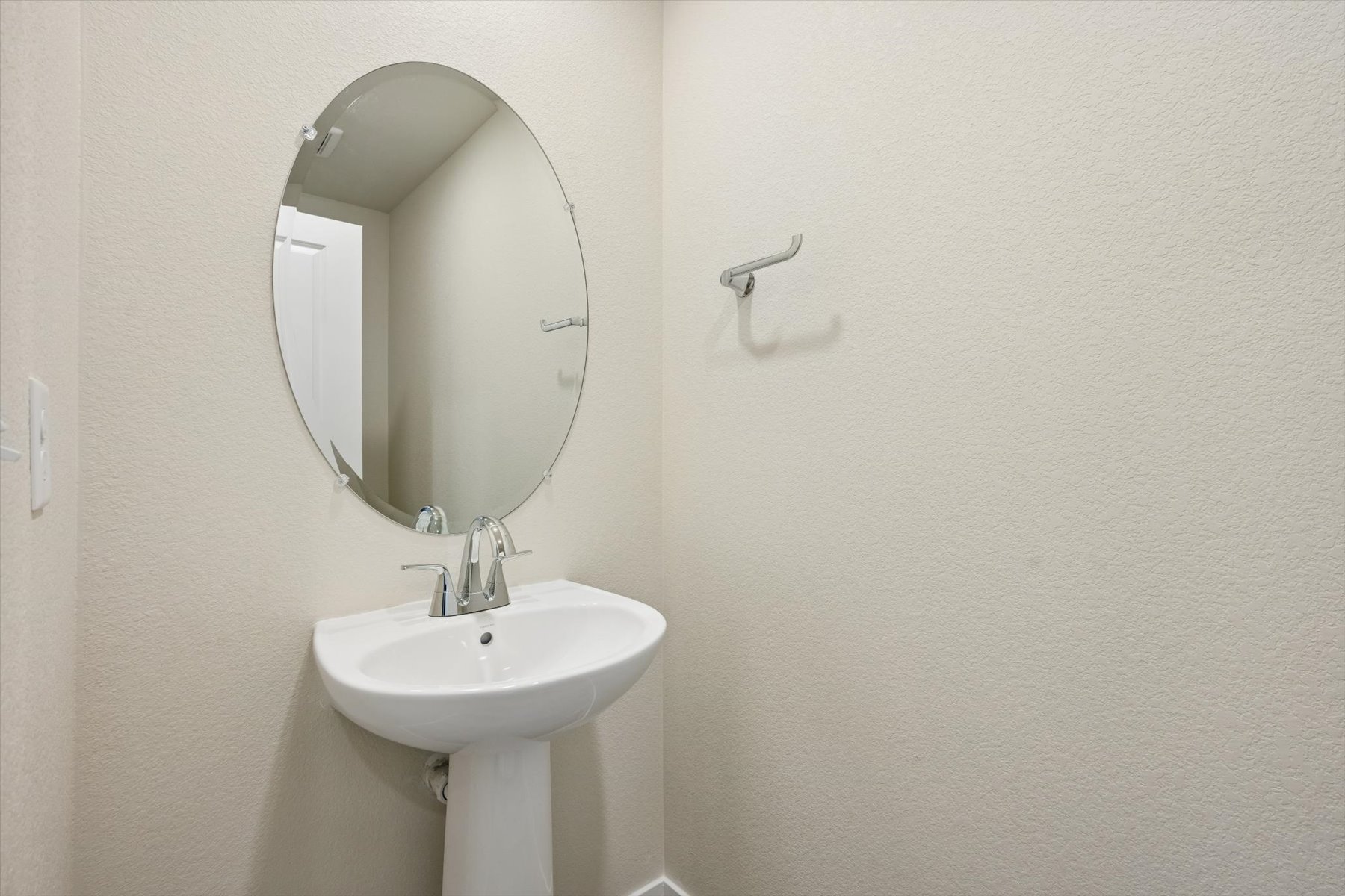 A bathroom with a round mirror.
