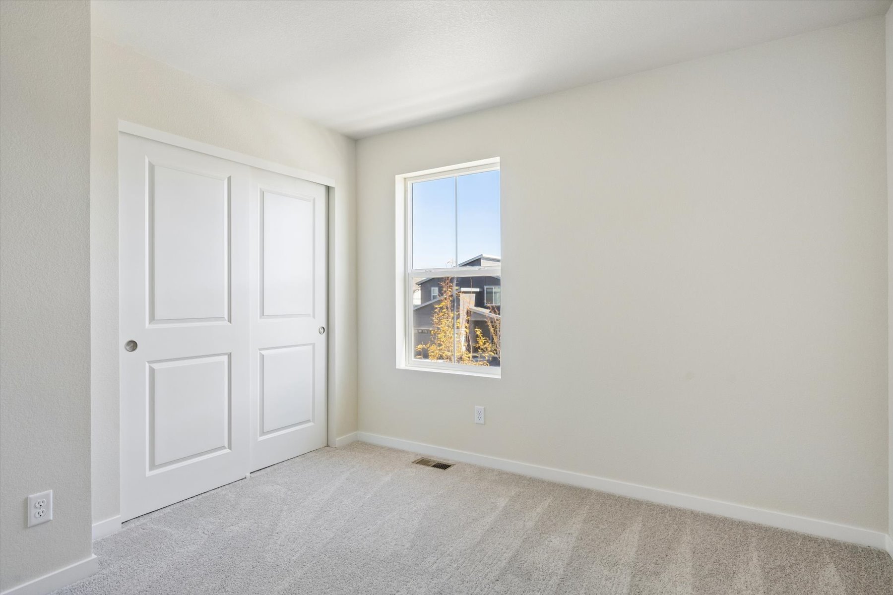 A room with white doors and a window.